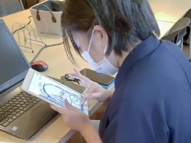 タブレットでイラストを描く女の子。